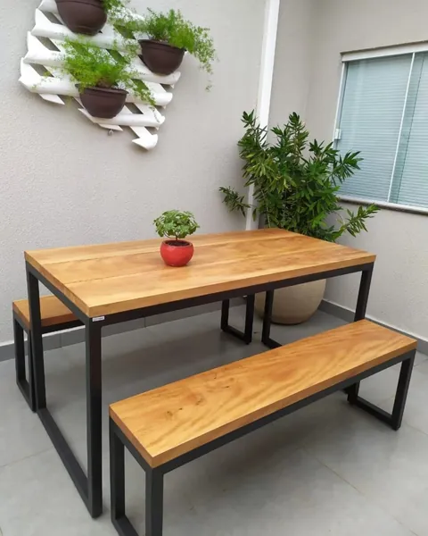 Mesa y bancos con estructura de hierro negro y tapa de madera en un patio