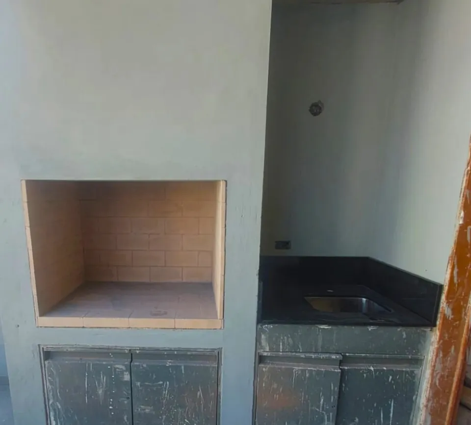 Quincho con parrilla y puertas metálicas en el sector bajo